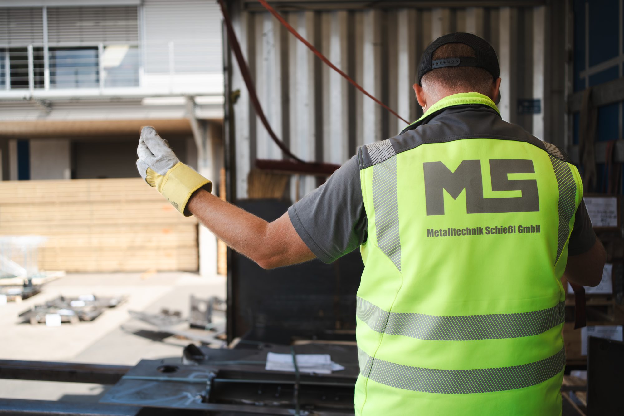 Mitarbeiter der MS Metalltechnik Schießl GmbH bei der Fertigung auf dem Werksgelände, mit Schutzweste und Handschuhen