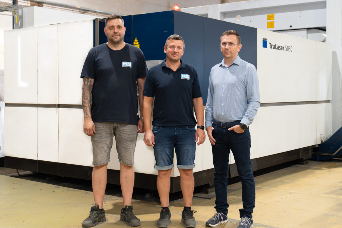 Geschäftsführer Mathias Schießl, Paul Michalski und Michal Sebo stehen vor der TRUMPF TruLaser 5030 in der Fertigungshalle der MS Metalltechnik Schießl GmbH in Rötz
